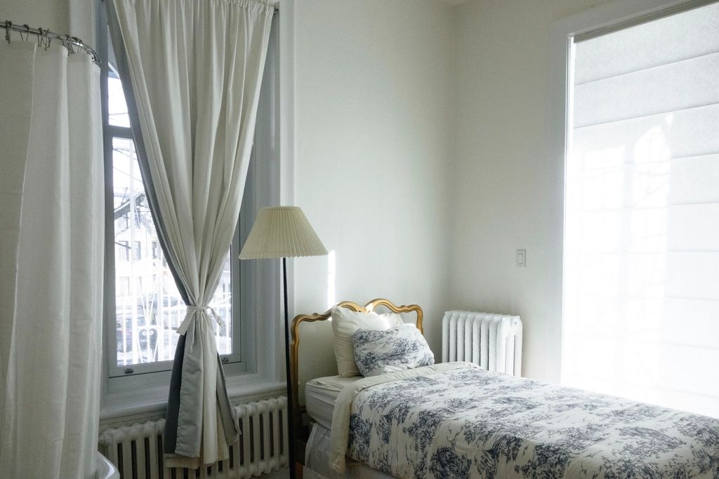 A guest room with two beds and a window